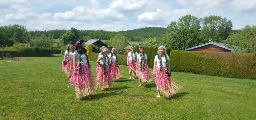 Gruppe Menschen in traditionellen Röcken auf einer Wiese