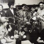 Gruppe von Frauen betrachtet und arrangiert Blumen.