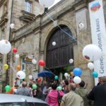 Feier vor dem Storchencafé mit Ballons und Menschenmenge.