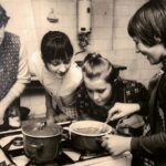 Vier Personen kochen gemeinsam in einer Küchenumgebung.
