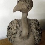 Tonfigur eines Vogels mit großem Hals und detailliertem Gefieder.