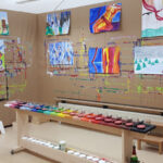 Buntes Kunststudio mit Gemälden und Farbpaletten.