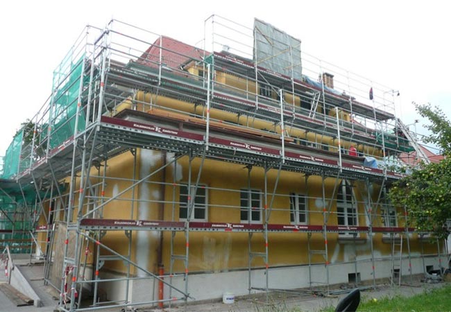 Gelbes Gebäude mit Gerüst im Renovierungsprozess